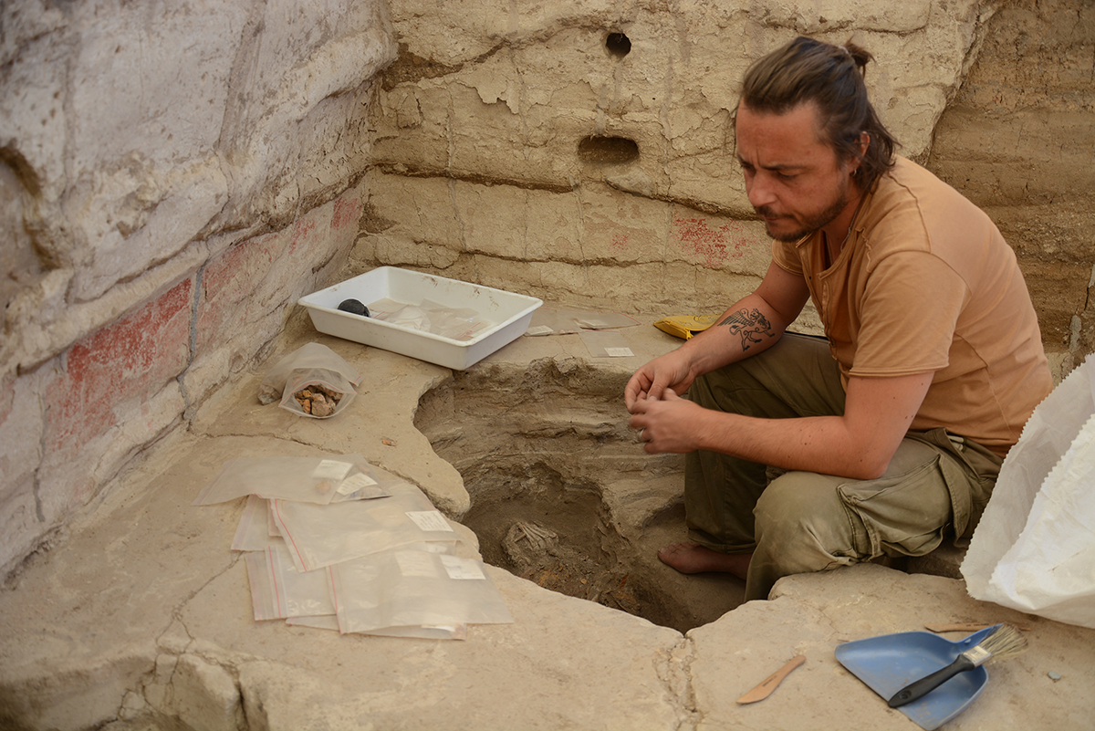 Marco Milella gräbt ein Skelett aus, das in einem Gebäude mit Wandmalereien in Çatalhöyük begraben ist.