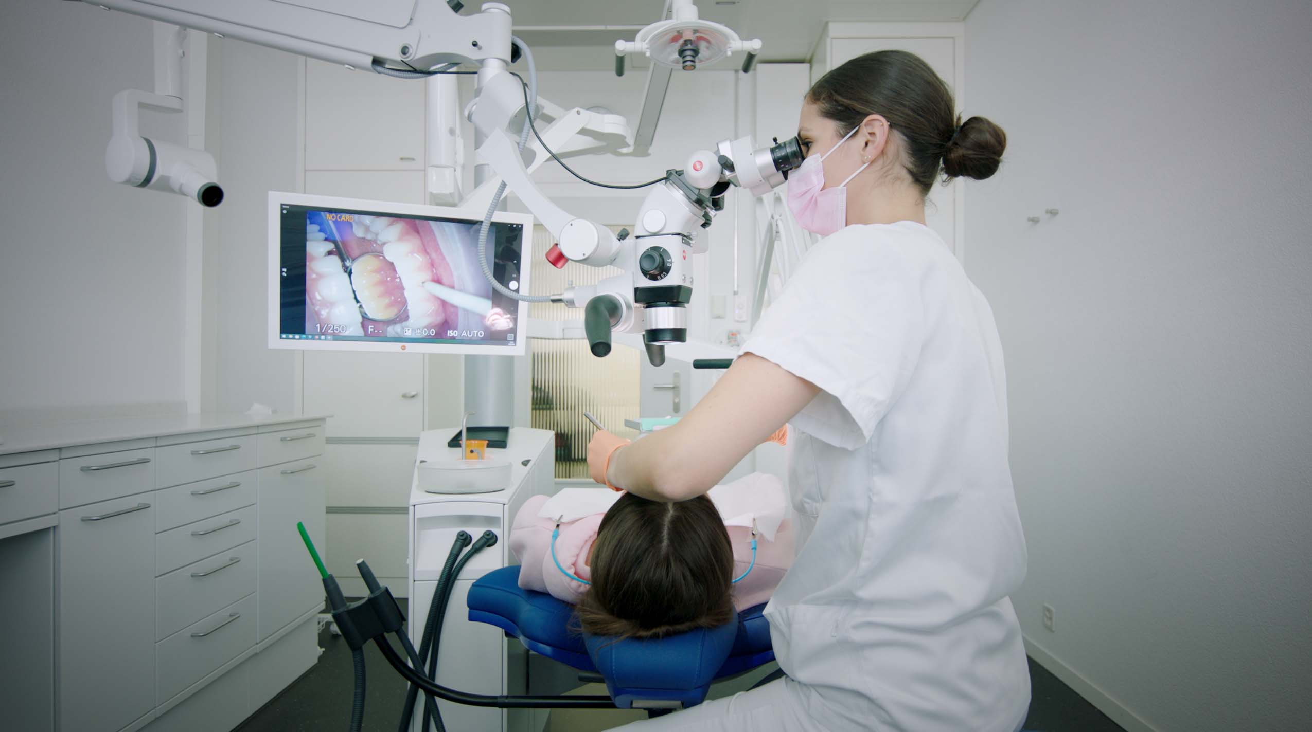 Aktuelles Behandlungszimmer der zmk mit Mikroskop und Röntgen an der Dentaleinheit.