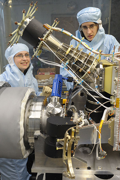 Im Bild sind zwei Doktorandinnen zu sehen, die Tests am ROSINA Massenspektrometer vornehmen.