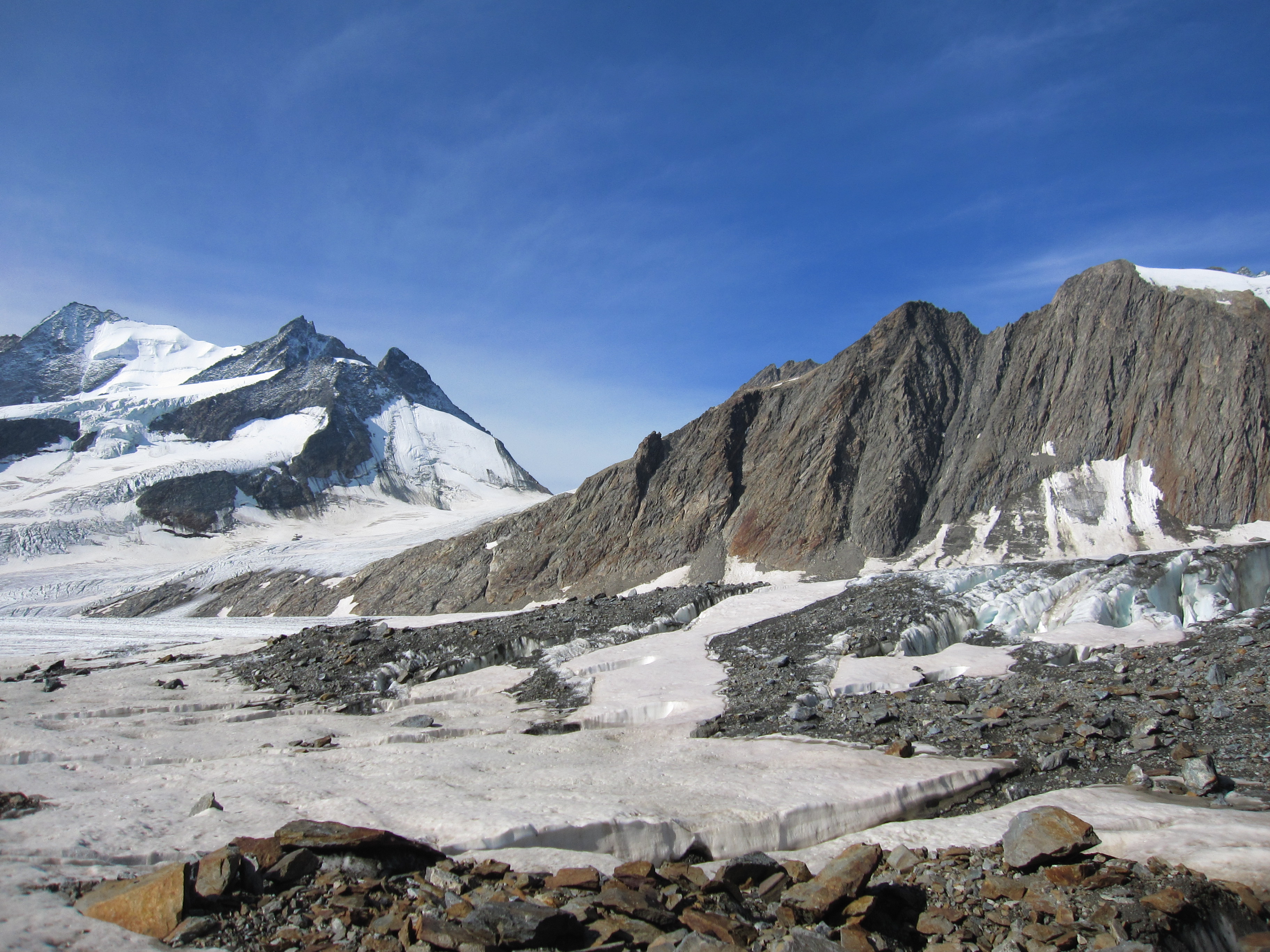 Morphologische Einschnitte in den steilen Felswänden des UNESCO-Welterbe Jungfrau-Aletsch zeugen von leichter erodierbaren steilen Störungszonen. Auch der Einschnitt der Grünhornlücke (Bildmitte) ist auf das präferenzielle Einschneiden durch die Glazialerosion zurückzuführen. Bild: Marco Herwegh