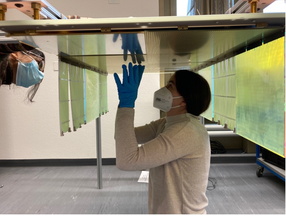 Dr. Saba Parsa und Anja Gauch vom Laboratorium für Hochenergiephysik (LHEP) der Universität Bern (v.l.n.r) beim Zusammenbau von einem Modul des «2x2»-Prototyps an der Universität Bern. Die auf der oberen Fläche sichtbaren kleinen Kupfer-Quadrate ermöglichen die 3D-Bildgebung. Die grünen Panele auf der Seite des Moduls zeichnen Lichtblitze der Neutrino-Wechselwirkungen auf. Dieser Aufbau wird zur Messung in flüssiges Argon getaucht.