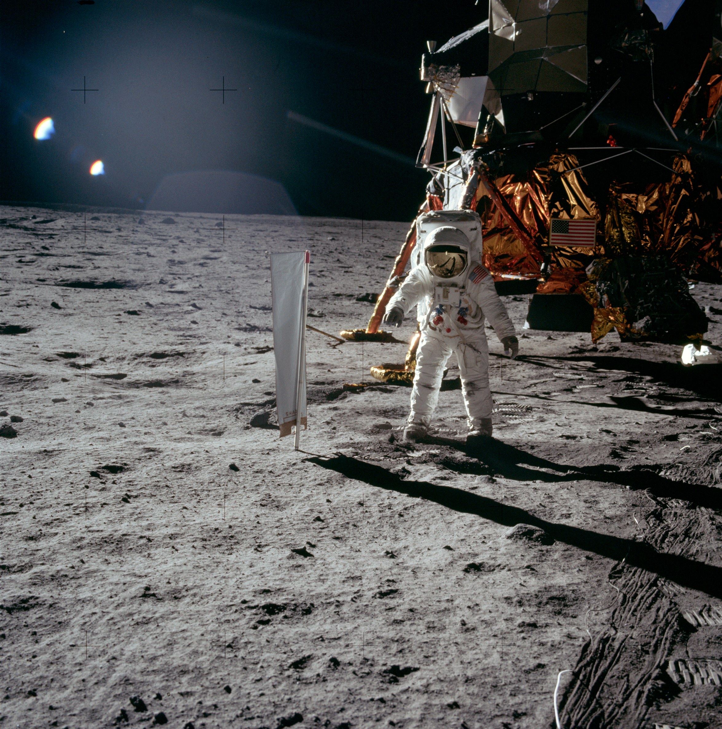 Juli 1969: Apollo 11 auf dem Mond mit dem Sonnenwind-Segel (SWC) des Physikalischen Instituts der Universität Bern. Es fing die Gase von der Sonne ein. Diese wurden in Bern mit speziell dafür entwickelten Massenspektrometern gemessen. Astronaut Edwin «Buzz» Aldrin steht neben dem Berner Experiment. © NASA, Apollo Image Archive.