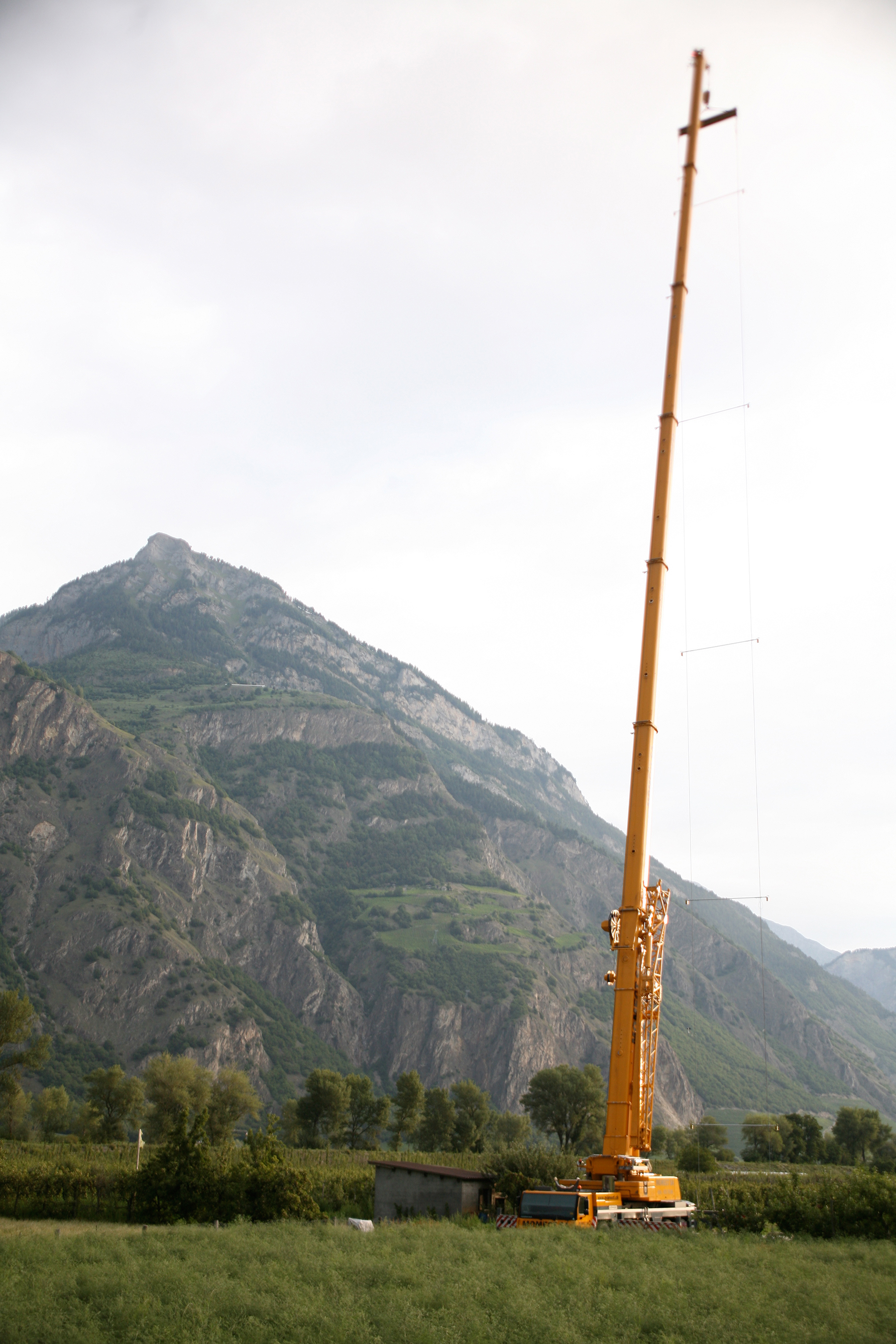 Die Ultraschalldetektoren wurden mithilfe eines Teleskopkrans entlang von zwei senkrecht zu Boden gespannten Kabeln, bis auf eine Höhe von 65 m, befestigt. Auf diese Weise war es möglich, die artspezifischen Flugaktivitätsprofile der Fledermäuse zu rekonstruieren. © Raphaël Arlettaz, IEE, Universität Bern