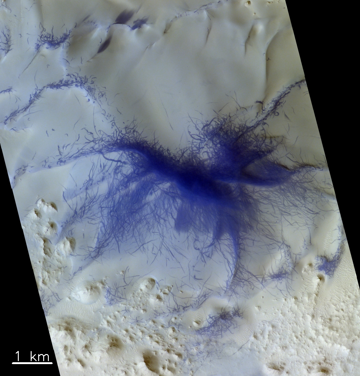Aufnahme aus der Terra Sabaea-Region westlich des Augakuh Vallis. Mehrere Grate sind mit Strichen bedeckt. Diese sind höchstwahrscheinlich Spuren von Staubteufeln (Luftwirbeln). Die blaue Färbung macht Strukturen auf der roten Marsoberfläche sichtbarer – in Echtfarbe wären die Striche dunkelrot. © ESA/Roscosmos/CaSSIS