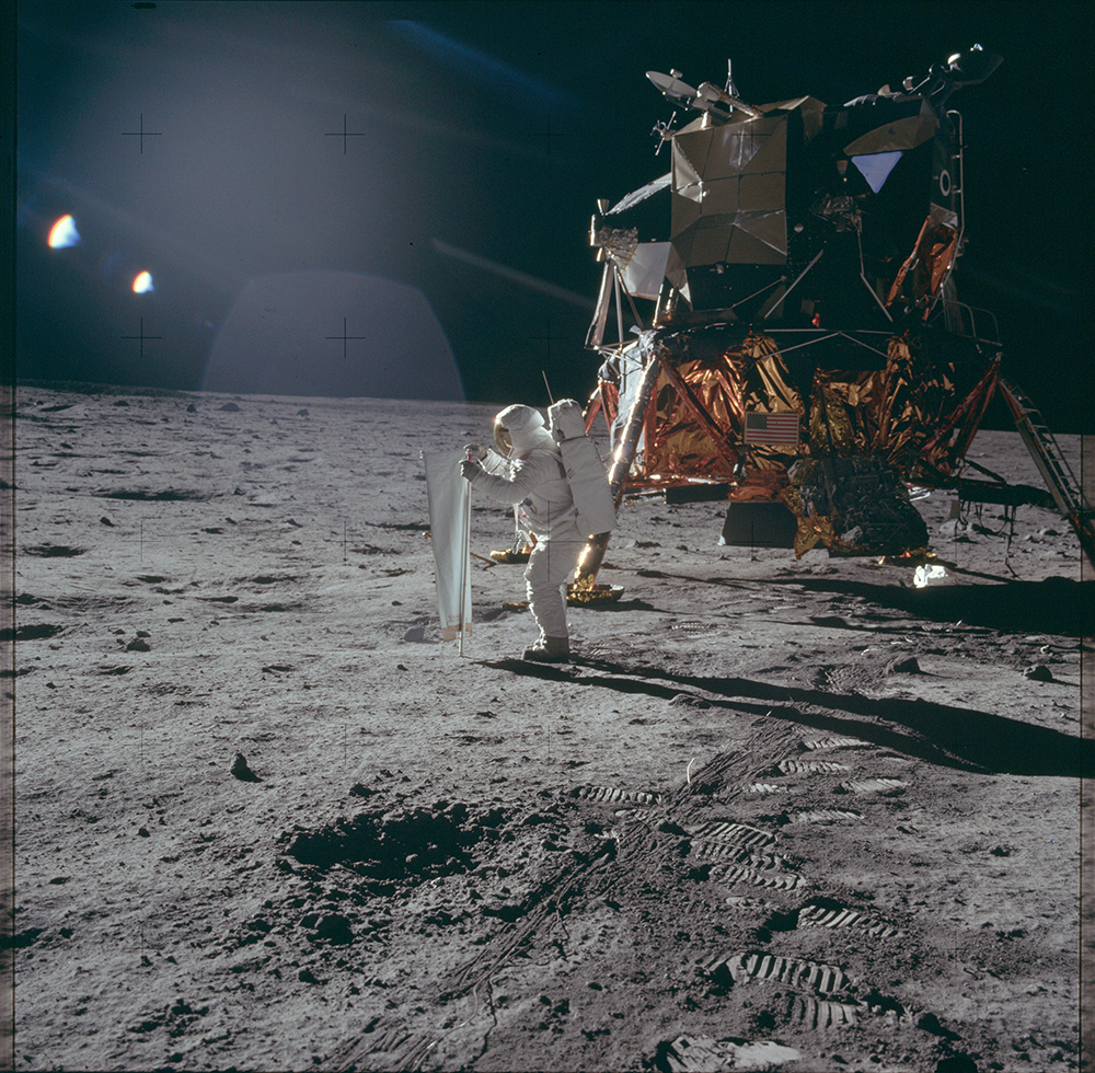 Astronaut Edwin «Buzz» Aldrin entrollt das Sonnenwindsegel der Universität Bern auf dem Mond.  Bild: NASA Apollo Image Archive
